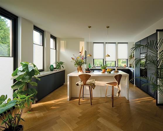 Luxaflex Duette Shades keuken visgraatvloer hout grote zwarte keuken plisségordijnen kookeiland leefkeuken