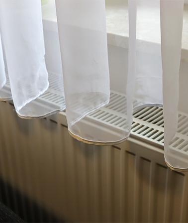Gordijnen boven radiator verwarming witte vitrage over de vensterbank