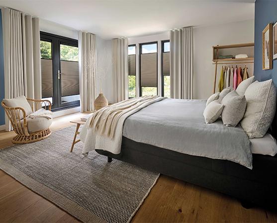 Slaapkamer met Luxaflex® Duette Shades en gordijnen