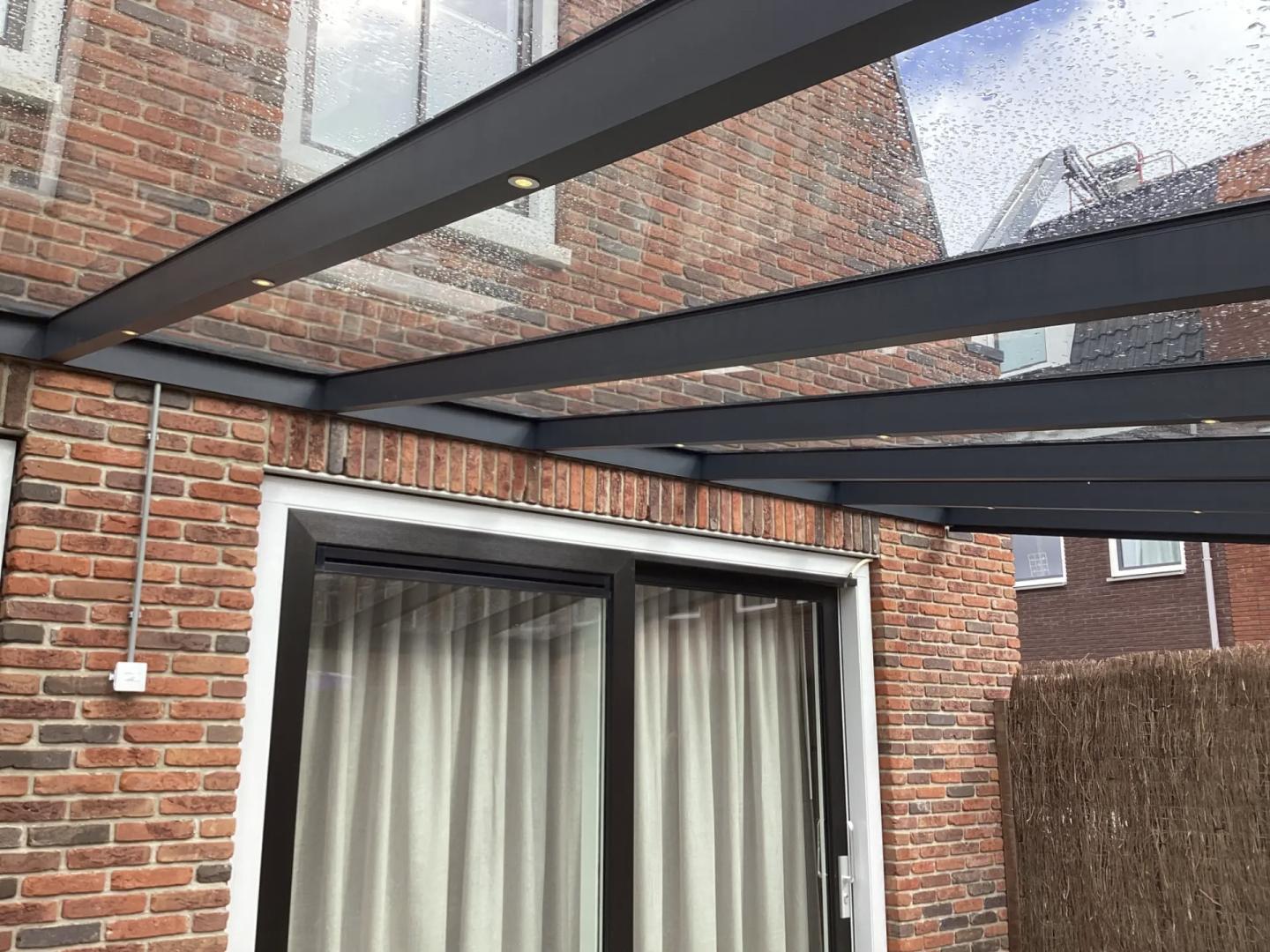 Solano Terrasoverkapping Muuraanbouw | Profielkleur: Antraciet fijnstructuur RAL7016 | Vulling: Helder Glas 44.2  | 9-spots LED-verlichting