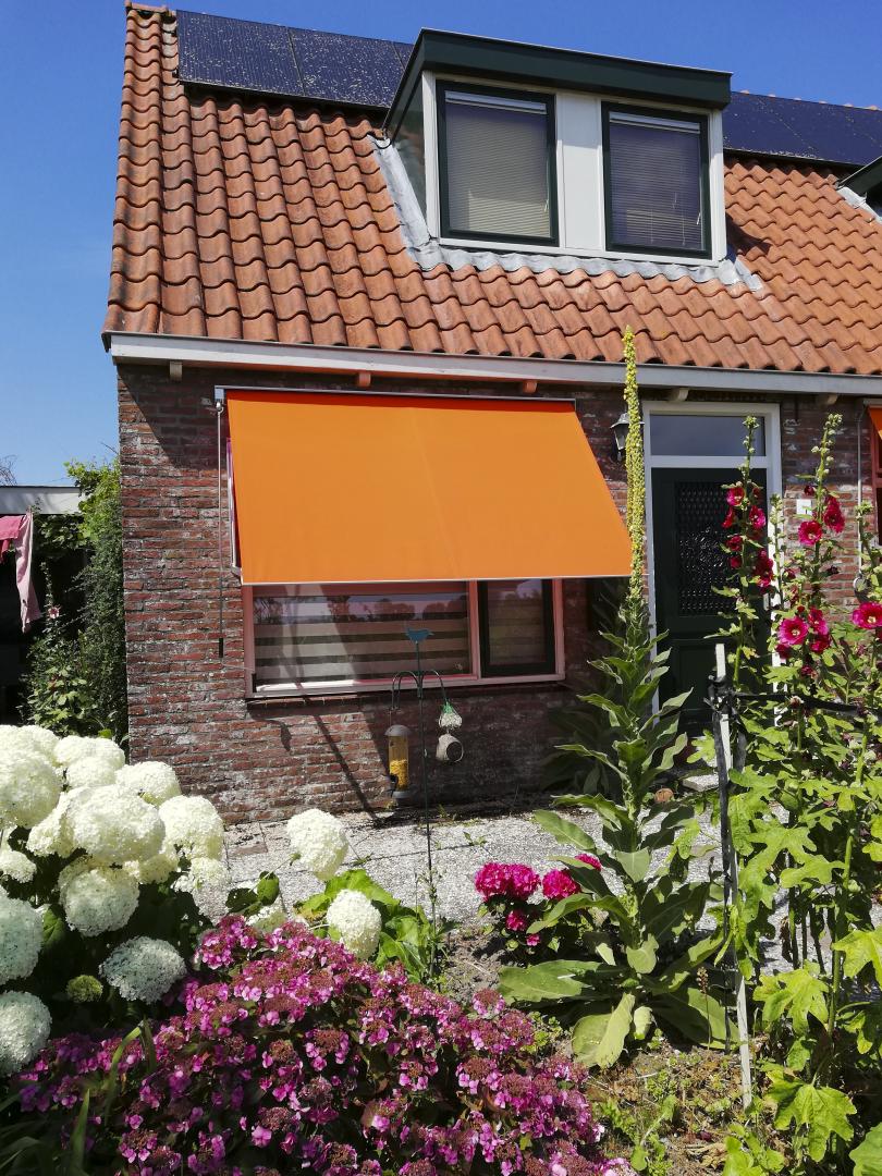 Solano uitvalscherm ACTIE | Profielkleur: Technisch zilver | Stofkleur: Urban Colors fel oranje 70.2504 | Stormvaste RVS veren | Bediening: slingerstang